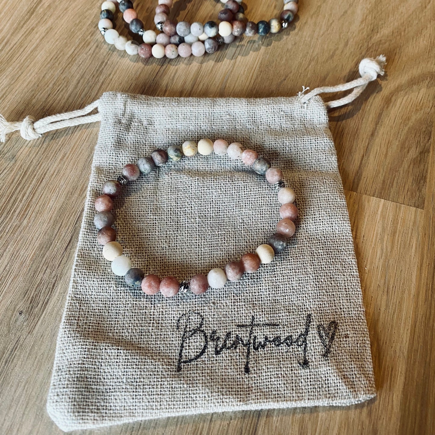 Mixed Marble Aroma Bracelet - 6mm beaded diffuser bracelet made from mixed marble & natural white wooden beads with platinum plated balls as embellishments. Laid on cloth pouch/drawstring bag stamped with “Brentwood” and a heart.