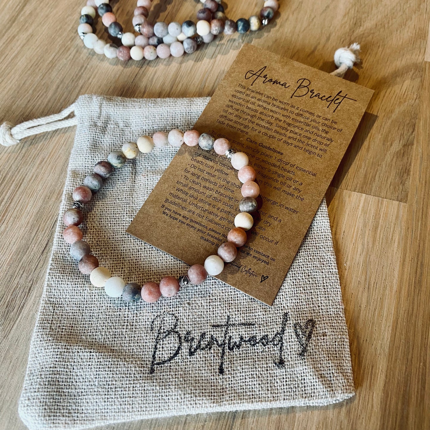 Mixed Marble Aroma Bracelet - 6mm beaded diffuser bracelet made from mixed marble & natural white wooden beads with platinum plated balls as embellishments. Laid on cloth pouch/drawstring bag stamped with “Brentwood” and an aroma bracelet information and care card on kraft brown card.